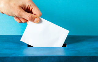 hand putting vote into box
