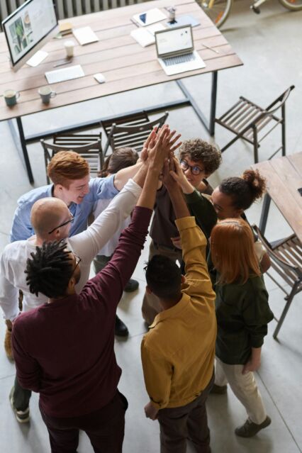 A group of people after a meeting holding each other's hands in the air