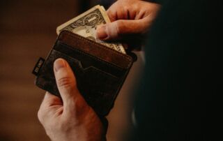 man opening his wallet and some cards and a bill sticking out