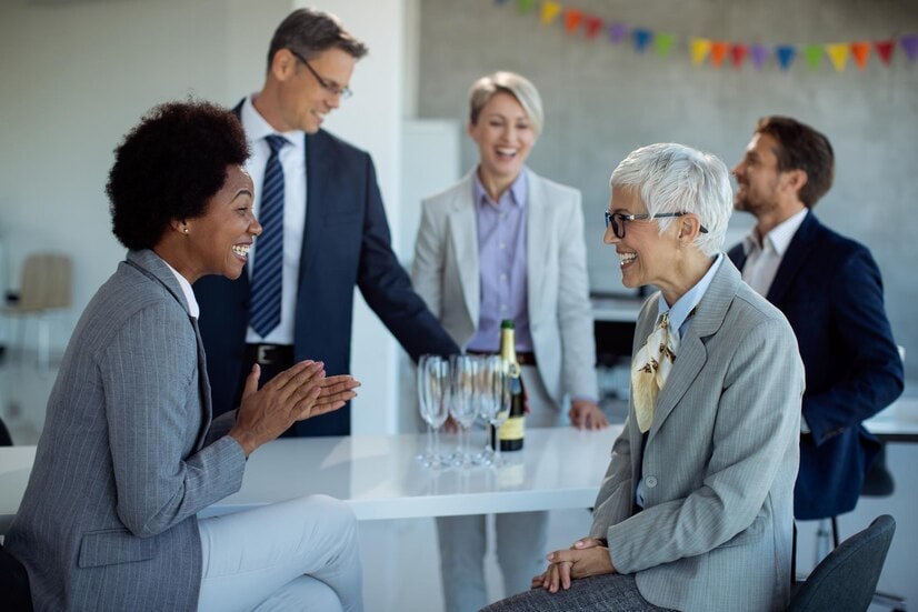 A group of professionally dressed association members speak, working toward strong member engagement.